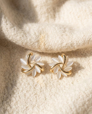 By Sophi Opal Petal Stud Earrings Gold flat-lay on warm cream wool