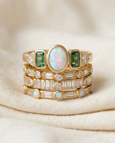 Vintage opal and zirconia stacking ring set on cream textile, four gold-tone bands with mixed-stone tops