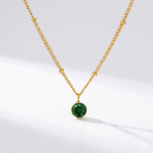 Emerald birthstone pendant necklace in gold-toned chain. By Sophi.