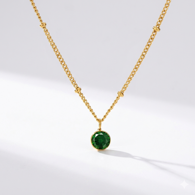 Emerald birthstone pendant necklace in gold-toned chain. By Sophi.