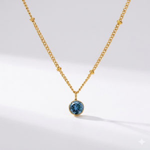 Sapphire birthstone pendant necklace in gold-toned chain. By Sophi.