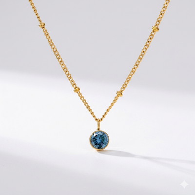 Sapphire birthstone pendant necklace in gold-toned chain. By Sophi.
