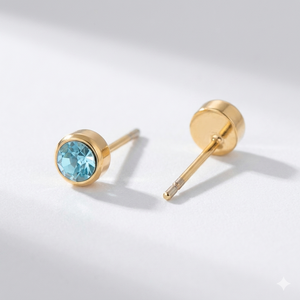 Aquamarine birthstone stud earrings in gold-toned bezel. By Sophi.