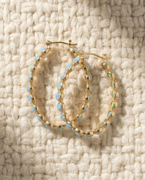 By Sophi Vintage Blue Opal Golden Hoop Earrings flat-lay on warm cream