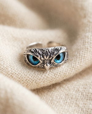 By Sophi Owl of Good Luck Adjustable Ring in Silver and Opal flat-lay on warm cream wool
