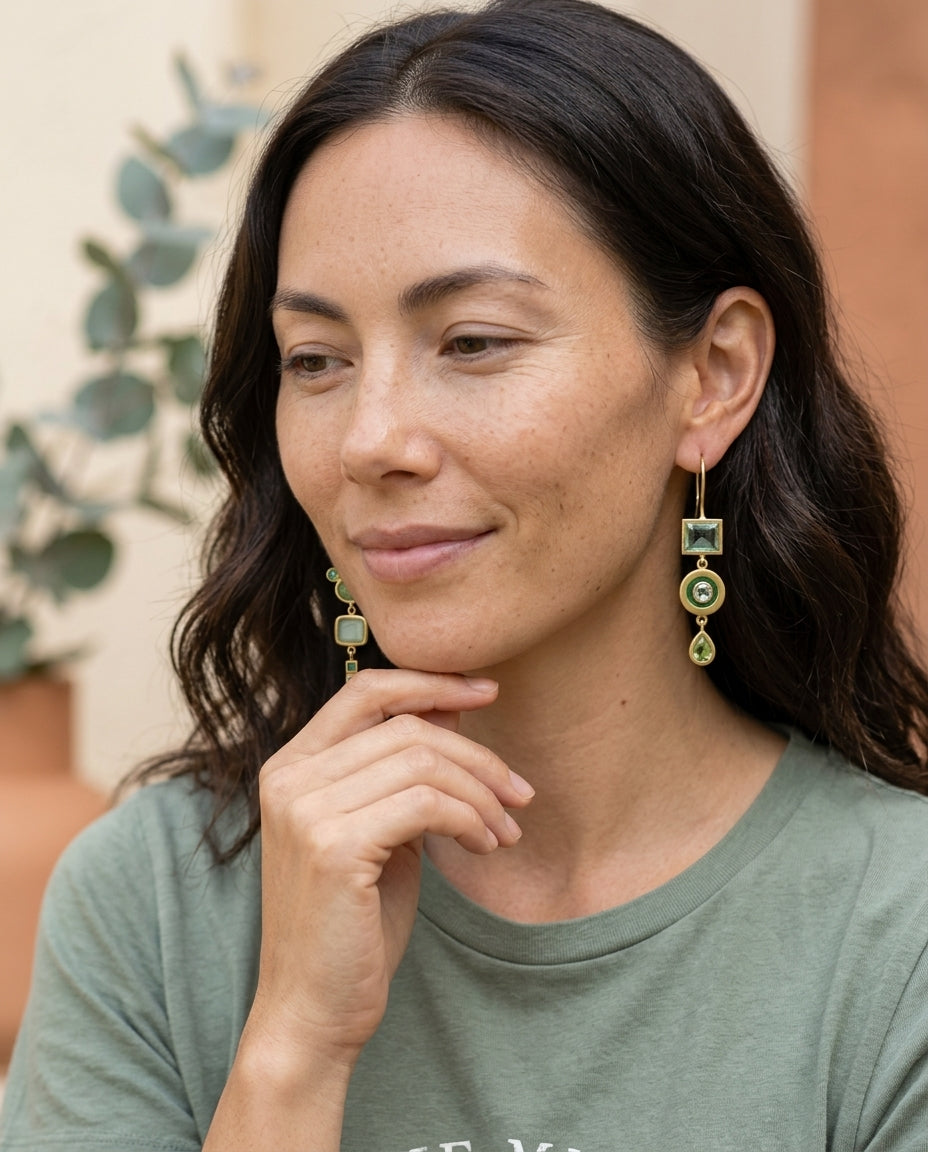 Vintage green dangling earrings on an East Asian woman in a soft garden setting