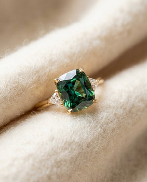 By Sophi Green Zirconia Ring in Gold flat-lay on warm cream wool