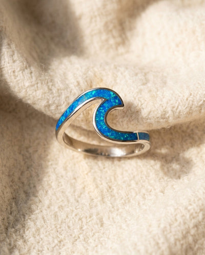 By Sophi Sea Wave Ring in Blue Opal & Silver flat-lay on warm cream wool
