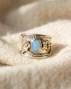 Vintage blue opal ring on cream wool, silver engraved band with small gold florals at the shoulders